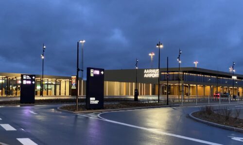 Bil ankommer til lufthavn med skilte til Kiss and Fly og parkering med LED-display for ledige pladser